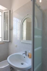 uma casa de banho com um lavatório, um WC e um espelho. em Villetta Terme di Torre Canne em Torre Canne