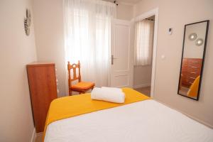 een slaapkamer met een bed, een stoel en een spiegel bij Apartamento Plaza Mar in La Herradura