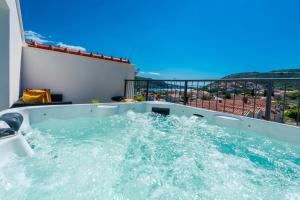 bañera de hidromasaje en el balcón de una casa en Aria Suite & SPA Dubrovnik, en Dubrovnik