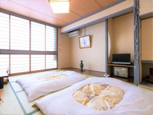 a bedroom with a bed and a tv at Tabist Sakadojo Minamiuonuma in Minami Uonuma