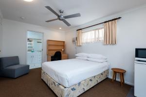 a hotel room with a bed and a tv at Sunshine Coast Airport Motel in Marcoola