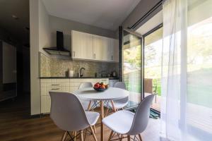 a kitchen and dining room with a white table and chairs at Róża Wiatrów in Węgorzewo