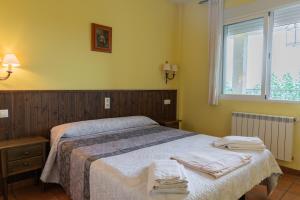 a bedroom with a bed with towels on it at Apartamentos rurales Casas de Haches in Las Casas de Haches