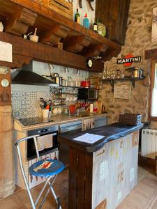 a kitchen with a counter and a blue stool at Zaldierna al sol, aldea del siglo XVIII Ezcaray in Zaldierna