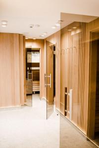 a dressing room with wooden walls and glass doors at Hotel Weissenstein in Sankt Michael im Lungau