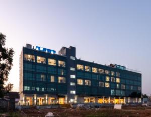 a large glass building with its lights on at Svenska Design Hotel Kakinada in Kākināda