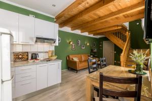 a kitchen with white cabinets and a dining room at Main Square Duplex with Rooftop Terrace in Split