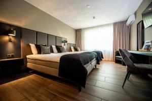 een hotelkamer met een bed en een bureau bij Maashof in Venlo