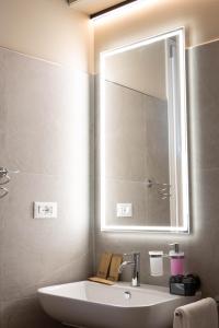 a bathroom with a sink and a mirror at Vespasiani Suites in San Benedetto del Tronto +46 photos
