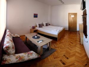 a room with a bed and a couch and a table at Gile Guest House in Veliko Tŭrnovo