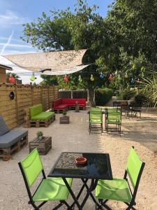 un patio con sillas verdes y una mesa con en Camping L' Arlesienne, en Arles