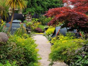 a walkway in a garden with flowers and trees at Tropical Garden Oasis Rooms in Birmingham