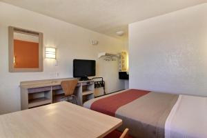 Habitación pequeña con 2 camas y escritorio con TV. en Motel 6-Abilene, TX en Abilene