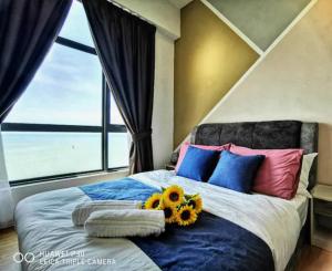 a bedroom with a bed with flowers on it at Gothca Imperium Residence Kuantan Studio Seaview in Kuantan +51 photos