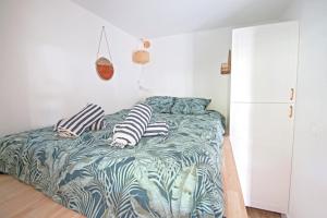 ein Schlafzimmer mit einem Bett mit Kissen darauf in der Unterkunft Motte du Couchant, 6 personnes, 4 min de la plage, Parking, Climatisation in La Grande-Motte