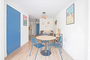 ein Esszimmer mit einem Tisch und blauen Stühlen in der Unterkunft Motte du Couchant, 6 personnes, 4 min de la plage, Parking, Climatisation in La Grande-Motte