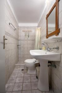 a bathroom with a white sink and a toilet at LITHARI PENTHOUSE in Alikanas