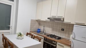 a kitchen with white cabinets and a table with a white counter top at Villa Crikvenica in Crikvenica