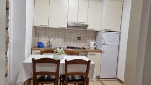 cocina con mesa con sillas y nevera blanca en Villa Crikvenica, en Crikvenica