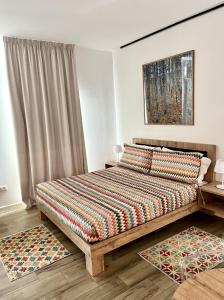 サン・ベネデット・デル・トロントにあるVespasiani SUITES & APARTMENTSのベッドルーム1室(カラフルな掛け布団付きのベッド1台付)