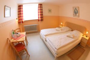ein Schlafzimmer mit 2 Betten und einem Tisch mit einem Tisch in der Unterkunft Gästehaus Grüner Baum in Sankt Martin