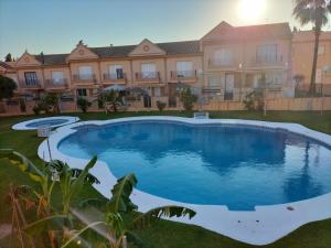 einem großen Pool vor einem Gebäude in der Unterkunft APARTAMENTO EN URBANIZACIÓN AL-ÁNDALUs CERCA DE LA PLAYA DE LA BARROSA in Chiclana de la Frontera