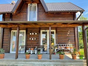 Cette maison en bois dispose d'une terrasse, d'une table et de chaises. dans l'établissement Bajka na dan two bedroom apartment, à Gradiška