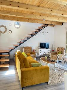 - un salon avec un canapé jaune et des escaliers dans l'établissement Bajka na dan two bedroom apartment, à Gradiška