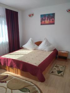 ein Schlafzimmer mit einem Bett mit einem roten Vorhang in der Unterkunft Vila Bogdan in Buşteni