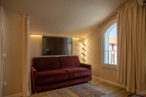 a red couch in a room with a window at Vespasiani Suites in San Benedetto del Tronto