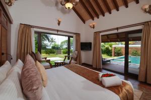 a bedroom with a large bed and a pool at Gokulam Grand Resort & Spa, Kumarakom in Kumarakom