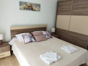 ein Schlafzimmer mit einem Bett mit zwei Handtüchern darauf in der Unterkunft Sea & Sun apartments in Žman