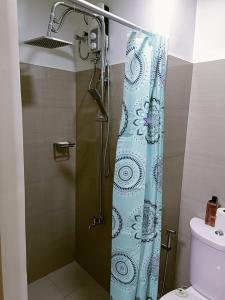 a bathroom with a shower with a blue shower curtain at Home away from Home in Manila