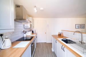 een keuken met witte apparaten en houten aanrechtbladen bij Elizabeth: Charming two bedroom apartment in centre of town in Ramsgate