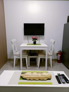 a white table with two chairs and a computer monitor at Home away from Home in Manila