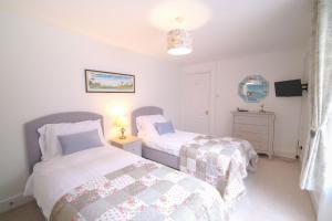 een slaapkamer met 2 bedden en een televisie. bij Elizabeth: Charming two bedroom apartment in centre of town in Ramsgate