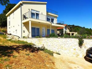 una casa su una collina con un muro di pietra di Sea & Sun apartments a Žman