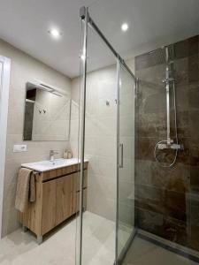 bagno con doccia in vetro e lavandino di Holidays2Malaga Princesa 3 dormitorios, vistas al mar y montaña, terraza y a 200m a la playa a Málaga