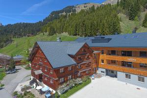 an aerial view of a large building with a mountain at Sonnenhof Appartements in Schröcken