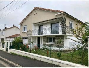 a white house with a balcony on a street at -Comme à la Maison- Jardin, Véranda, Idéal familles et Business in Niort