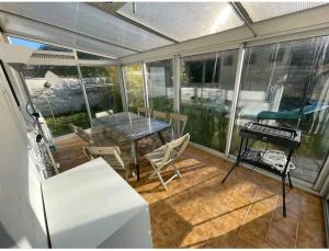 a screened in porch with a table and chairs at -Comme à la Maison- Jardin, Véranda, Idéal familles et Business in Niort