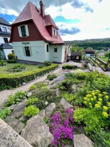 una casa con un jardín de flores delante de ella en Chalupa Sunny Cottage en Svoboda nad Úpou