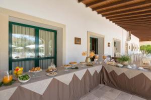 een lange tafel met eten erop in een kamer bij Masseria San Biagio in Calimera
