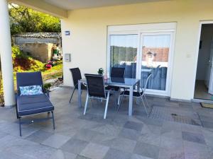 eine Terrasse mit einem Tisch, Stühlen und einem Fenster in der Unterkunft Sea & Sun apartments in Žman