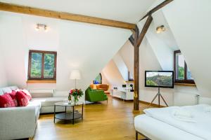 a living room with white furniture and a tv at Hotel Villa Vinum Cochem in Cochem