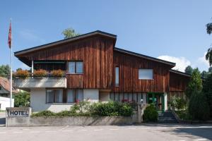 una casa de madera con flores en la parte delantera en Seminarhotel Linde Stettlen, en Berna