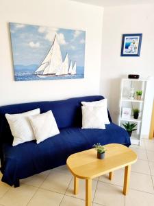 a blue couch in a living room with a sail boat at Sea view App Mirta in Umag