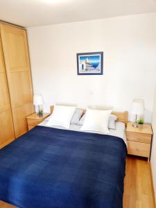ein Schlafzimmer mit einem blauen Bett und zwei Nachttischen in der Unterkunft Sea view App Mirta in Umag