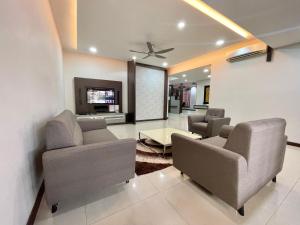 a living room with two couches and a tv at Langkawi Cozy Holiday Home at Bukit Indah by Zervin in Kuah