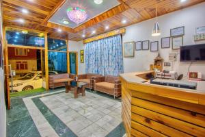 a living room with a couch and a tv at HOTEL ROYAL Manali in Manāli